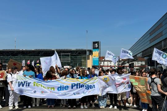 Blauer Himmel vor den Messehallen in Bremen im Mai 2024 und „Wir feiern die Pflege!"